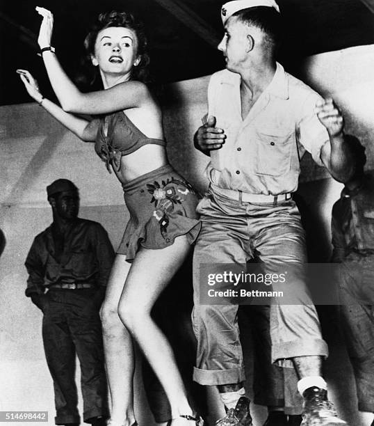 Patty Thomas, a dancer with Bob Hope's USO tour in the South Pacific, dances with a US Marine during World War II. | Location: southern Pacific Ocean.