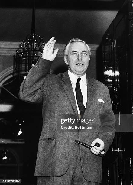 Harold Wilson, the brand new Labour Party Prime Minister, waves from the doorway of the Prime Minister's residence, No. 10, Downing Street.