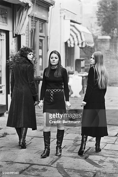 On a London street, one young woman defies fashion by continuing to wear the miniskirt, while two other young women wear the newer maxiskirt in 1967.