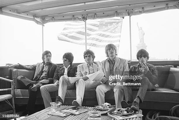 The Rolling Stones relax aboard a yacht while cruising along New York Harbor. Charlie Watts, Keith Richards, Mick Jagger, Brian Jones, and Bill Wyman...