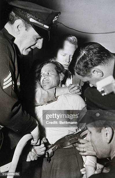 Hollywood, CA: Martin Eisinger, a former inmate of a Nazi concentration camp, struggles as police and detectives place him in a straight-jacket. Ten...