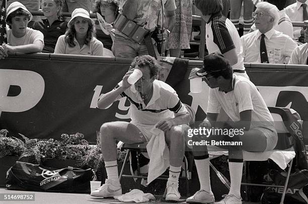 Tennis player John McEnroe pours water on his head as meets with team captain Arthur Ashe during a 1981Davis Cup Match in New York.