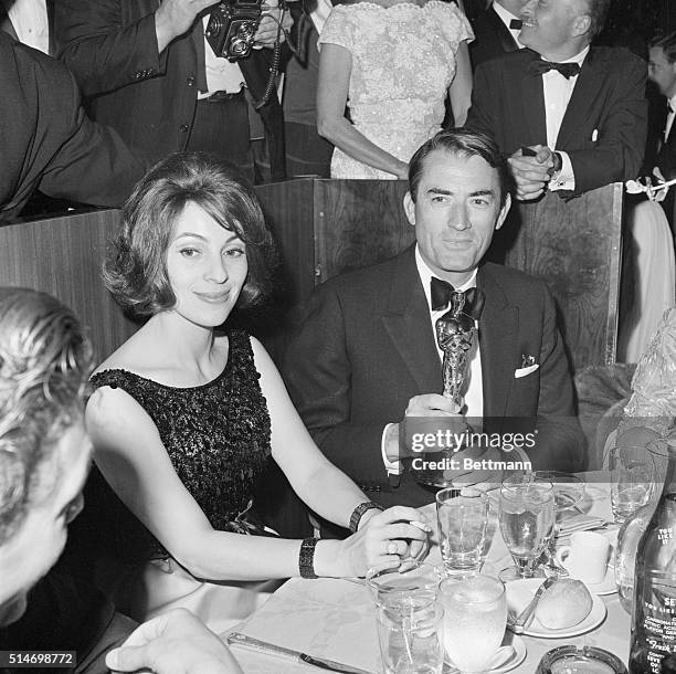 Gregory Peck sits with his wife Veronique and the Oscar he just won for Best Actor in To Kill a Mockingbird at the Academy Awards.