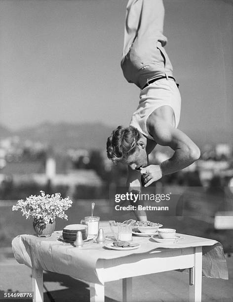 Los Angeles, California: If your stomach's a trifle upset, why not try this upside method of eating lunch, as recommended by seventeen year old...