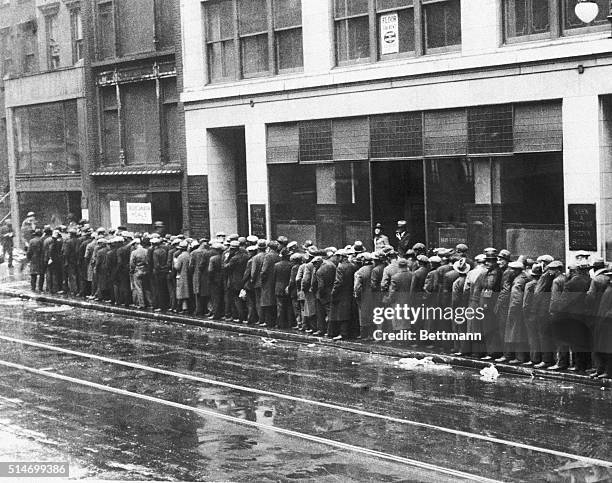 Unemployed men wait in long lines for bread and handouts during the Great Depression.