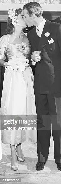 James Stewart kisses Gloria Hatrick McLean after their marriage at the Brentwood Presbyterian Church. They remained married for the rest of their...