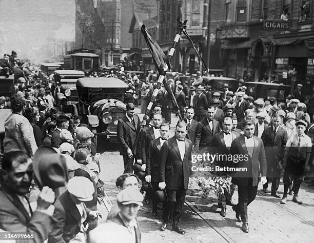 Funeral of a Chicago gangster. Streets that were dirty and sordid were transformed into lines of color today when the long funeral train of Angelo...