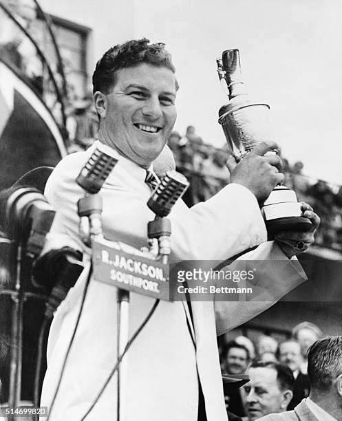 Southport, England: 24 year old Peter Thompson of Austrailia, winner of the 1954 British Open Golf Championship at Royal Birkdale last friday, holds...