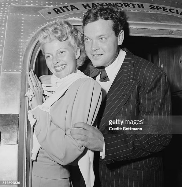 Los Angeles, CA: Their rumored disagreement apparently ended, Rita Hayworth, glamorous film star and her husband Orson Welles wave from their plane...