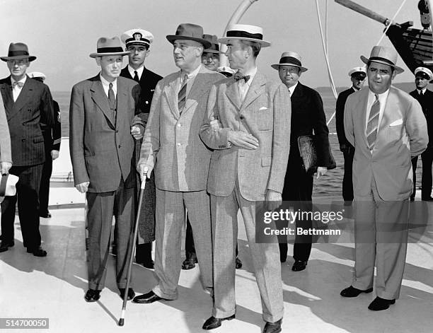 President Roosevelt prepares to disembark the yacht Potomac with lend-lease administrator Harry Hopkins and Captain John R. Beardall .