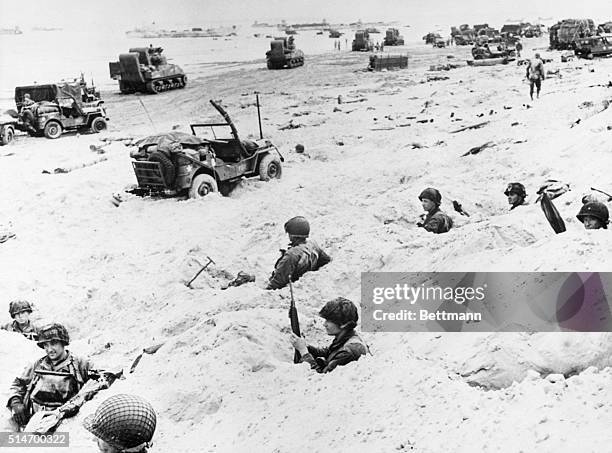 American soldiers wait in foxholes at Utah Beach on D-Day for the order to move inland against German fortifications.