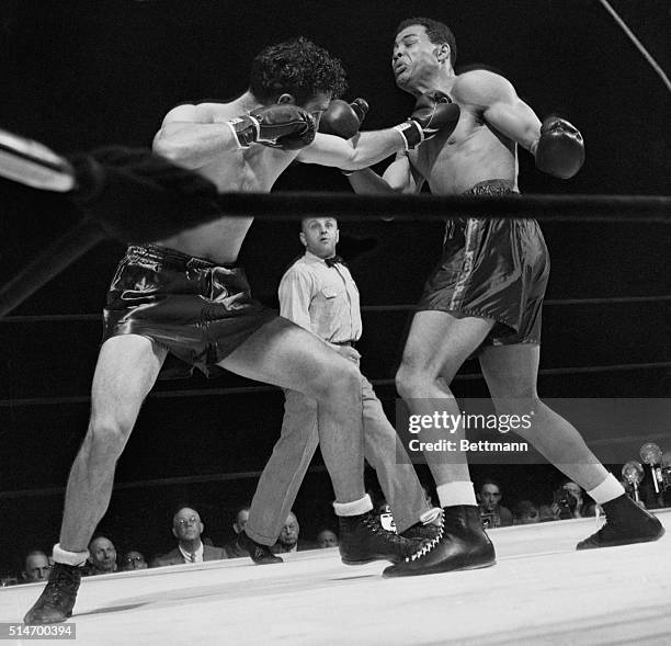 New York: Challenger Billy Conn, at left, stings champion Joe Louis with a left jab to the throat early in their scheduled fifteen round battle for...