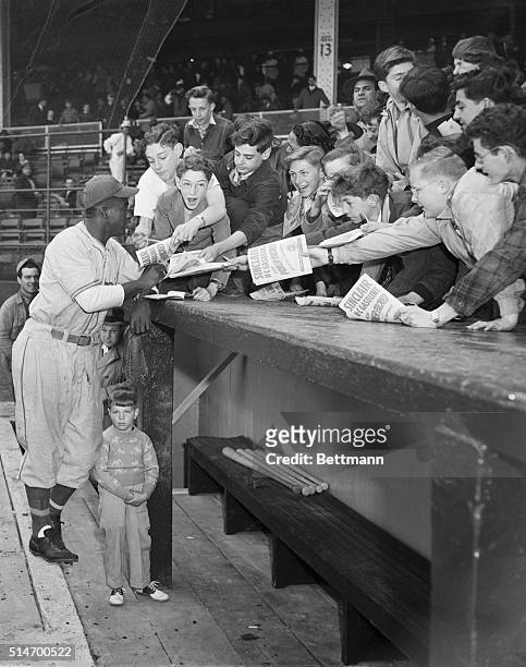 New York, NY: Jackie Robinson, gets a big hand from young Dodger rooters, who arrived early for the exhibition game between the Dodgers and Monteal....