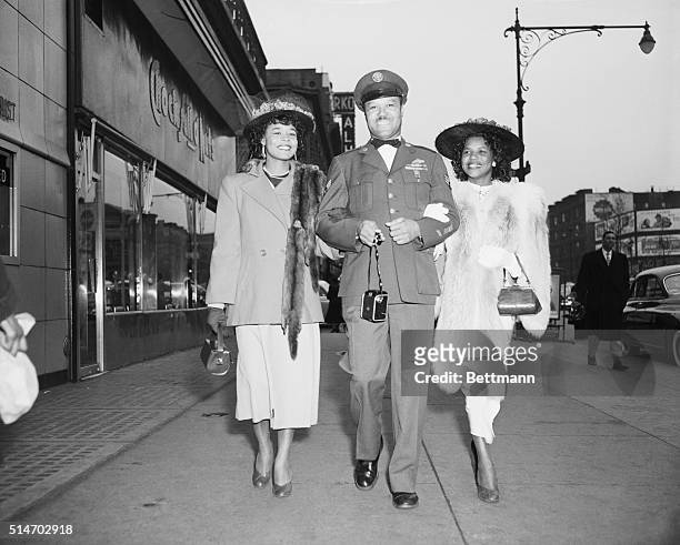 New York: Three bright smiles parade by the Hotel Theresa in New York's Harlem, greeting Easter Sunday with good cheer. Left to right are: Miss Jean...