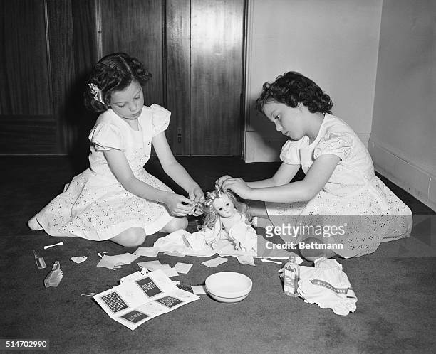 Chicago, IL: Joan and Murray, seven year old twins, put their new doll's hair up in curlers. The Toni doll was developed by the Ideal Novelty and Toy...