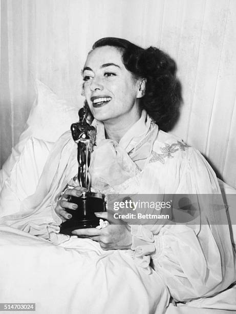 Joan Crawford holding her Academy Award.