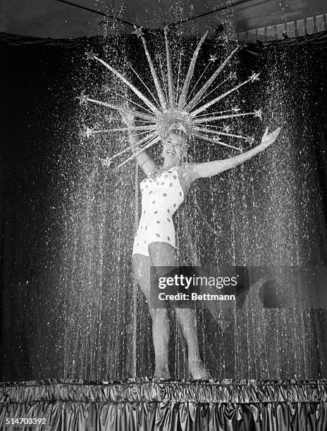 Las Vegas, NV: A glittering shower falls over an equally glittering headdress worn by lovely swimming star of the movies Esther Williams. Seemingly...
