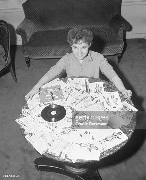 Paris, France: A little Miss with a big future, American singer Brenda Lee busily autographs photos of herself that she intends to send out to ehr...
