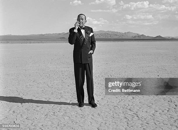 Las Vegas, NV: The bleak Nevada desert provides an unusual backdrop effect for Noel Coward, currently making his first American night club appearance...