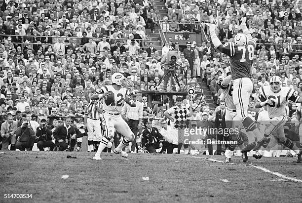 Bubba Smith , defensive lineman for the Baltimore Colts, lunges into the air in an attempt to block the pass from New York Jets QB Joe Namath during...