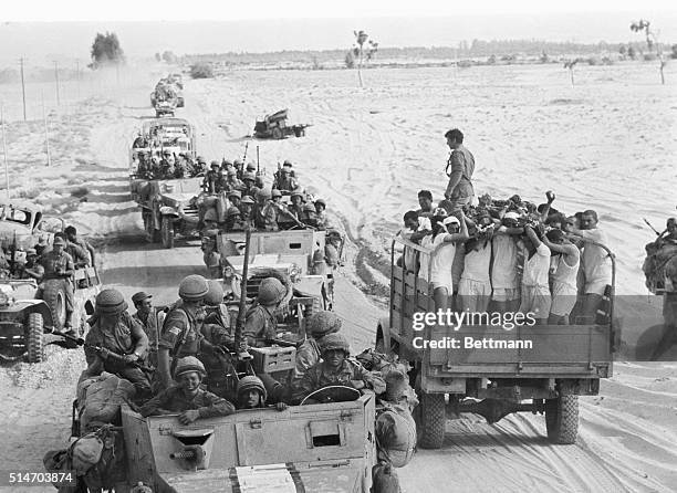 Truck full of captured Egyptian soldiers meets a convoy of Israeli troops near El Arish, Egypt. The Israelis had taken El Arish and are heading...