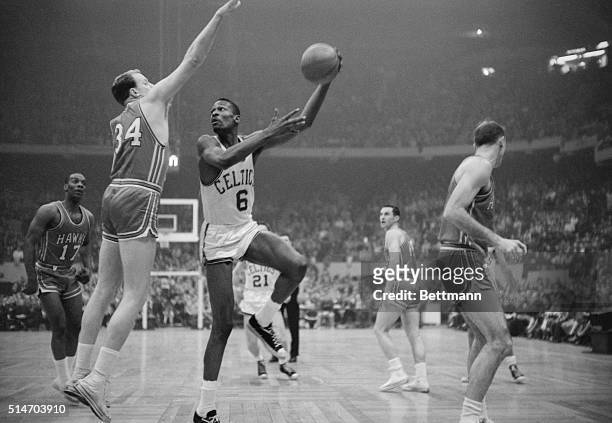 Boston Celtics' player Bill Russell hooks a shot during the NBA championship's final game in 1960 against the Saint Louis Hawks.
