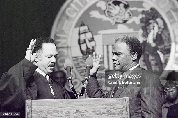 Cook County Circuit Court Judge Charles Freeman swears in Chicago's first African American mayor, Harold Washington during a ceremony attended by...