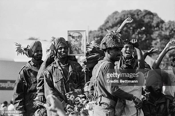 Dacca: Indian soldiers rejoice 12/16 after entering the capital of East Pakistan. One soldier holds up a picture of Awami League chief Sheikh Mujibur...