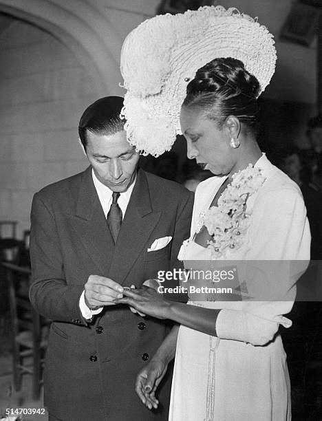 Bandleader Joe Bouillon places a ring on the finger of his bride, American dancer and singer Josephine Baker, in France. She had been a French...