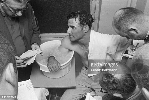 Reporters interview Montreal Expos pitcher Bill Stoneman as he soaks his arm in ice after pitching a no-hitter against the Philadelphia Phillies,...