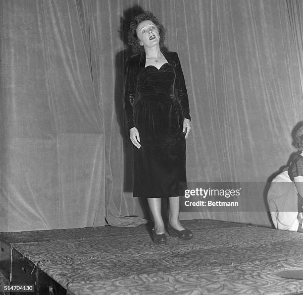 New York, NY: Nightclub singer Edith Piaf carries on the show at a swanky New York night club, the Versailles, during the evening of the same day she...