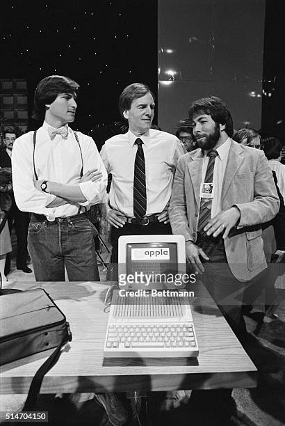 John Sculley, President of Apple Computer, talks with Apple co-founders Steve Jobs and Steve Wozniak as they introduce the new Apple Iic computer at...