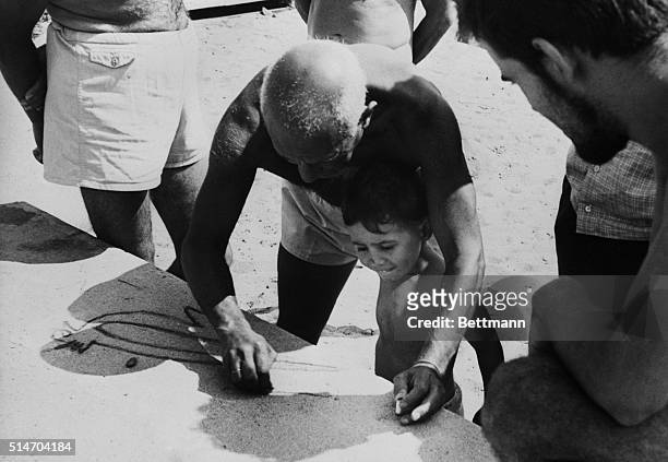 Vallauris, France:Spanish surrealist painter-sculptor Pablo Picasso sketches a pigeon on the pavment near Golfe Juan's beach for his son Claude,...