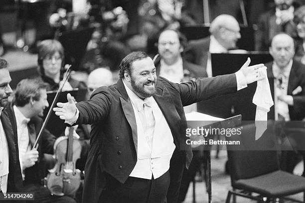 Luciano Pavarotti opens his arms and grins in a gesture of thanks to his audience during a concert with the New York Philharmonic under the direction...
