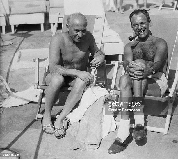 Miami Beach, FL: Sporting deep sun tans, screen comedian Harpo Marx and playwright Moss Hart relax at the Roney Plaza where they're vactioning.