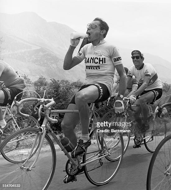 Ancona, Italy: As the Giro Bicycle Race "caravan" rolls through Ancona towards the Adriatic coast, Italy's ace, Fausto Coppi, sprays concentrated...