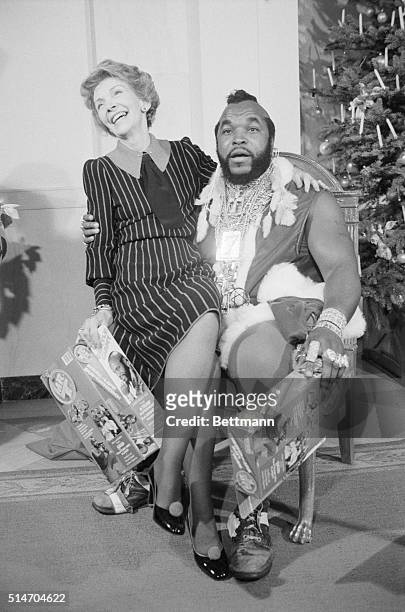 First Lady Nancy Reagan sits on the lap of television personality Mr. T.