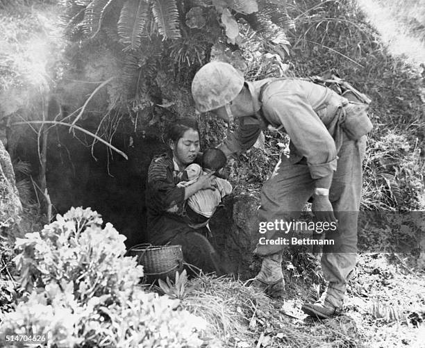 Okinawa, Japan: Eleven Okinawa civilians who were huddled in this hillside cave were rescued when a passing Marine patrol heard a baby crying. After...