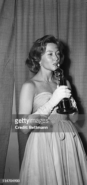Hollywood, CA: Film actress Gloria Grahame kisses the "Oscar" she won as "Best Supporting Actress" at the 25th annual Academy Awards presentation...