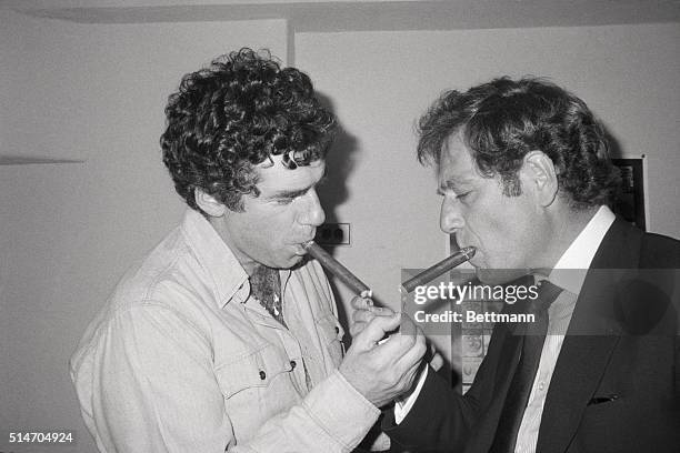 Elliott Gould & George Segal light each other's cigars backstage, after a preview of a play that Gould is starring in, "The Guys in The Truck". New...