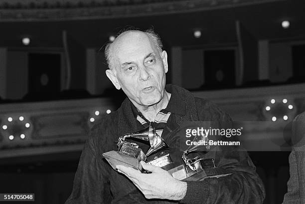 Portrait of Chicago Symphony Orchestra conductor Sir Georg Solti holding the four Grammys he won at the recent 1983 Grammy Awards.