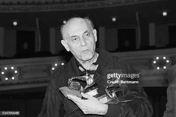 Portrait of Chicago Symphony Orchestra conductor Sir Georg Solti holding the four Grammys he won at the recent 1983 Grammy Awards.