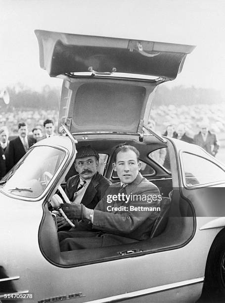 British racecar driver Stirling Moss test drives a Mercedes-Benz 300 SL sports coupe during a race meeting at Brands Hatch Circuit in Kent, England....