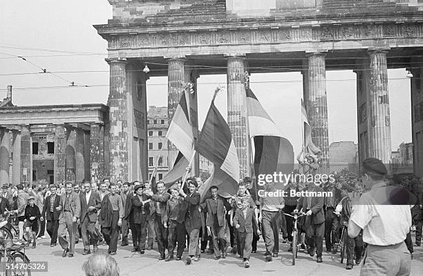 Berlin, Germany: East Germany demonstrators, some carrying banners, march through famed Brandenburg Gate into the Western sector of Berlin after...