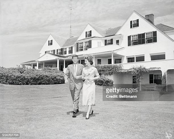 Senator John F. Kennedy and Miss Jacqueline Bouvier stroll across the lawn of his family's home after announcing their engagement.