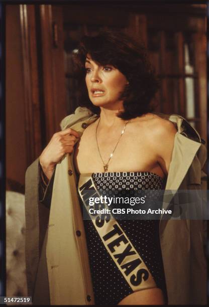 In a scene from the American television series 'Dallas,' American actress Linda Gray takes off her trenchcoat and reveals a one-piece swimsuit and...