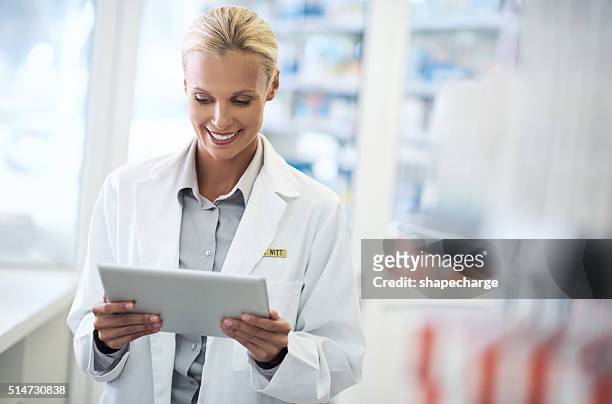 conheça o digital farmacêutico - female pharmacist with a digital tablet imagens e fotografias de stock