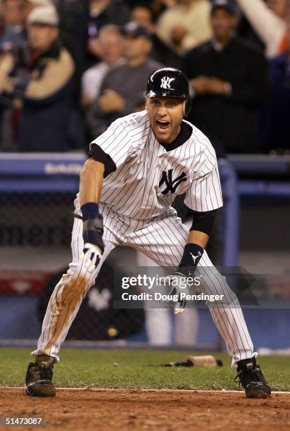 Derek Jeter of the New York Yankees gestures to teammate Alex Rodriguez as both score on a three-run double by Hideki Matsui against the Boston Red...