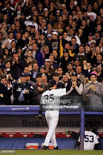 Pitcher Mike Mussina of the New York Yankees acknowledges the fans after being removed from the game in the seventh inning against the Boston Red Sox...