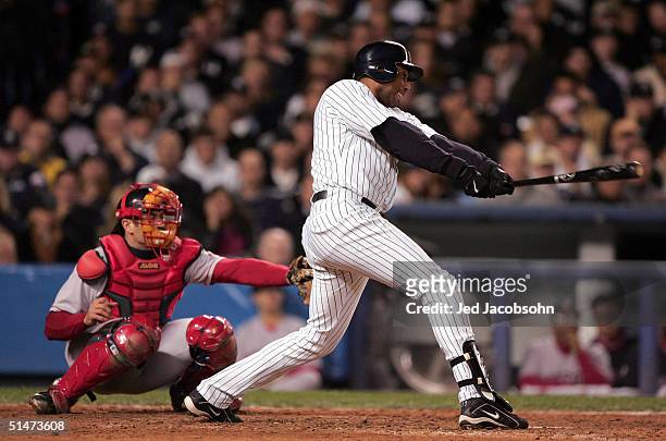 Bernie Williams of the New York Yankees hits a two-run double against the Boston Red Sox in the eighth inning during game one of the American League...